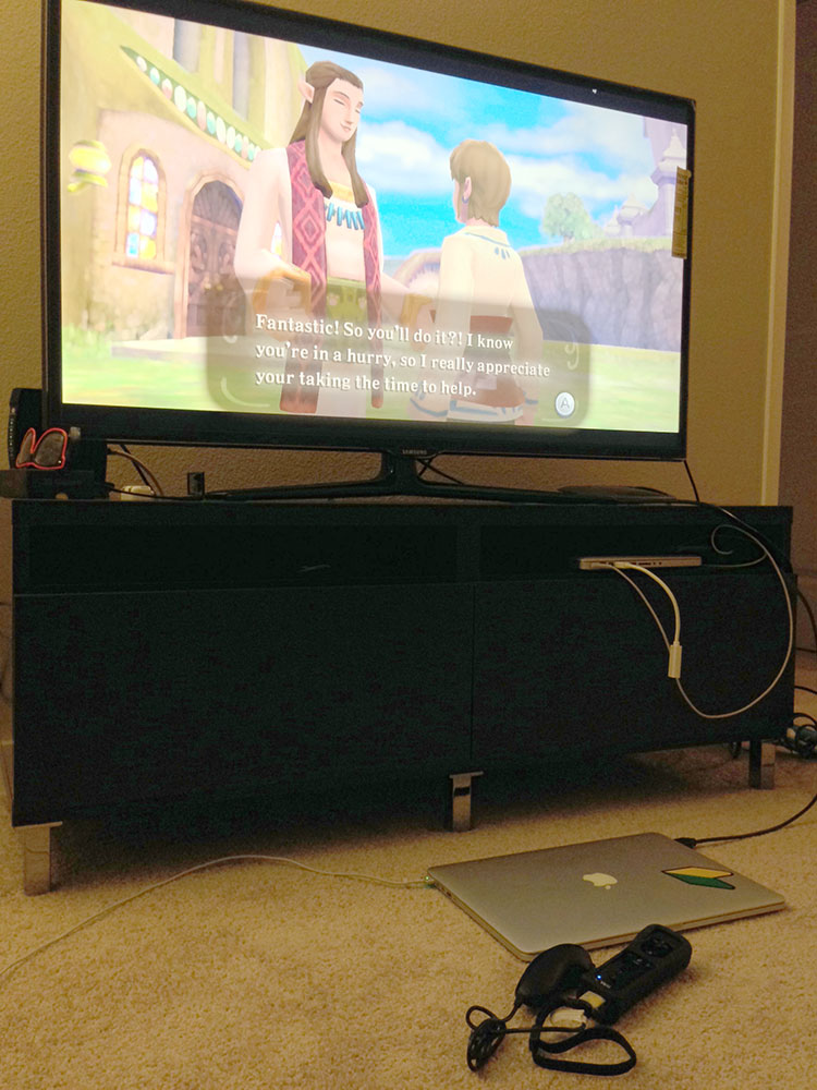 Photo of Dolphin Emulator on a MacBook Pro powering a TV with a game playing over HDMI