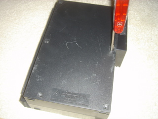 Removing the screws on a PlayStation 2 console.