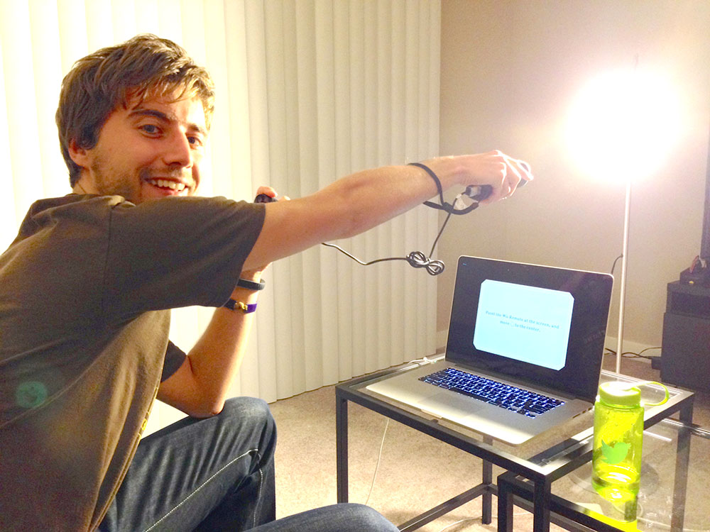 Photo of me using a floor lamp to calibrate the Wiimote controller instead of a sensor bar's infrared emitters