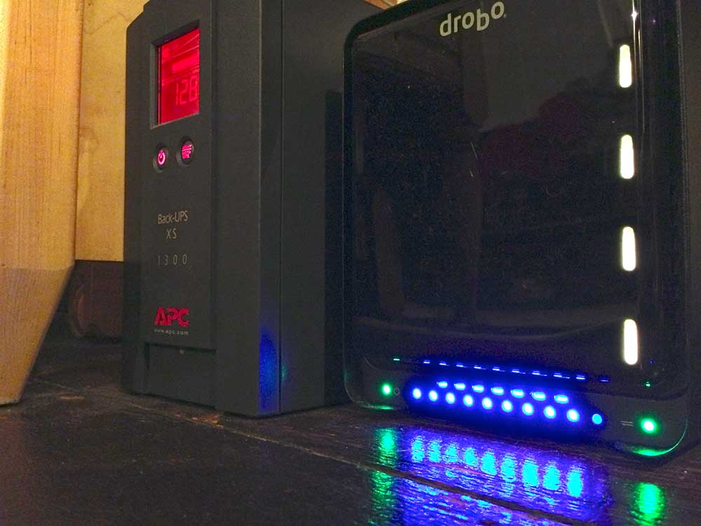 My Drobo setup… connected to an APC UPS for AC battery backup. (There's a 5th HDD bay and light near the top of this Drobo, but it's cut off by the top of the photograph.)